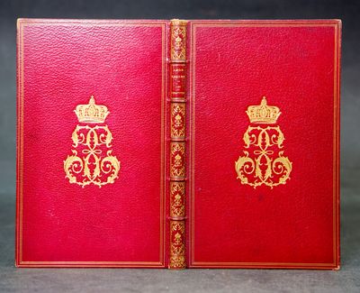 an old red book with gold trim and a crown on the cover