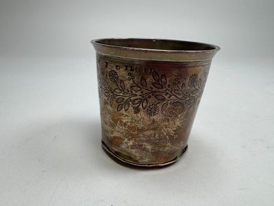 a silver cup with a floral design on it