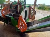 an image of a green and orange tractor parked on the side of the road