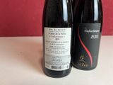 two bottles of wine sitting next to each other on a table
