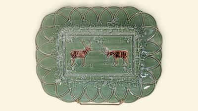 a green plate with a picture of two deers on it