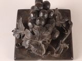 a metal plate with a bunch of grapes on it
