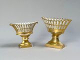 two gold vases sitting next to each other on a table