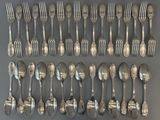 a group of silverplated forks and spoons on a table