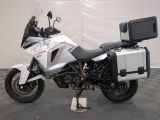 a motorcycle that is parked in a garage with a tv on the back of it