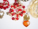 a lot of beads and necklaces on a white surface