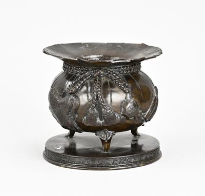 un vase en argent orné d'un dragon, posé sur un socle