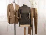 two mannequins and a suit on display in a room