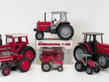 three toy tractors are sitting next to each other on a white surface
