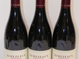 trois bouteilles de vin rouge sont alignées sur une table