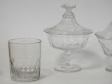 three glass containers and a glass cup sitting on a table