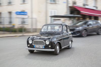 a black car driving down the street in front of a building