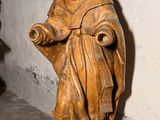 une statue représentant une femme tenant un livre dans une pièce