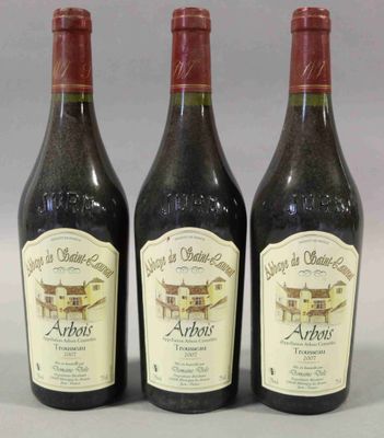 trois bouteilles de vin posées sur une table l'une à côté de l'autre