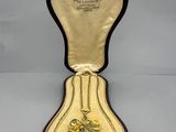 an open case with a heart shaped pendant inside of it