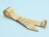 gold - plated watch band for a rolex watch on a blue background