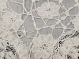 a close up of a white lace collar on a blue background