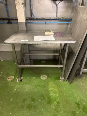 une table en métal sur laquelle se trouve un livre, dans une pièce