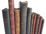 plusieurs vieux livres empilés sur une surface blanche