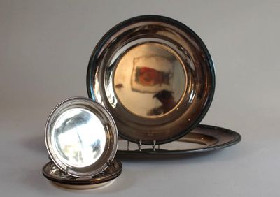 a silver plate with a mirror on it and a silver plate with a mirror on it