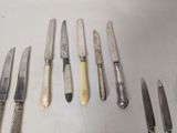a lot of knives that are lined up on a table