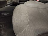 the interior of a car with a seat up and a cup holder in the center