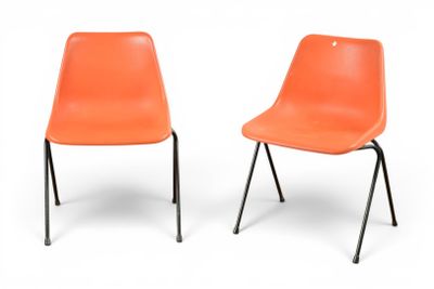 une paire de chaises en plastique orange aux pieds noirs, sur fond blanc
