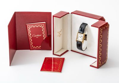 une boîte rouge contenant une montre et un livre