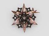 a close up of a broochle with a star design on it