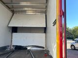 the back of a truck with the door open in a parking lot