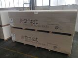 Deux palettes de cartons sont empilées sur des palettes dans un entrepôt