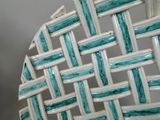 a close up of a white wicker chair with a blue and white pattern