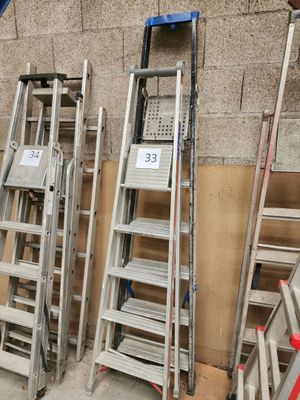 de nombreuses échelles empilées contre un mur