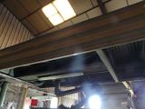a man that is standing under a car in a garage