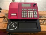 une calculatrice rose posée sur une table en bois