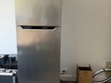 a silver refrigerator in the corner of a room