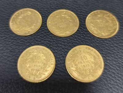 four gold coins sitting on top of a black leather surface