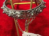bracelet en argent avec une chaîne et une plaque sur fond rouge
