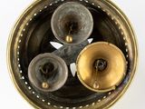 three bells in a metal bowl on a white surface