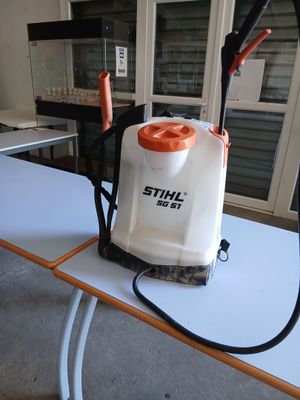 une table blanche sur laquelle se trouvent une poignée orange et un pulvérisateur blanc