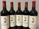 four bottles of red wine are lined up on a table