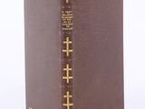 brown leather book with gold cross stitching on the front cover