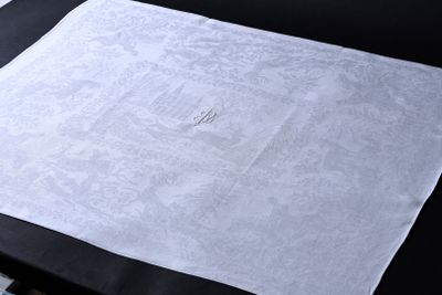 une serviette blanche ornée d'un monogramme, posée sur une table