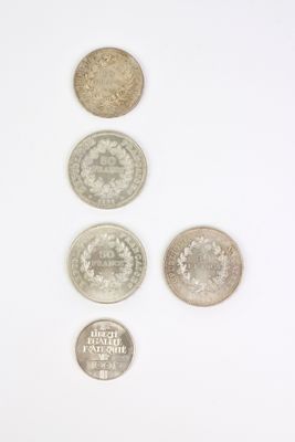 six types de pièces différents alignés sur une surface blanche