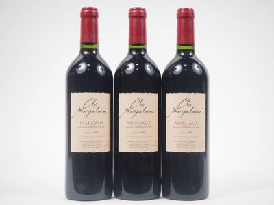 trois bouteilles de vin rouge posées l'une à côté de l'autre sur une surface blanche