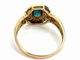 a close up of a gold ring with a green stone