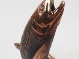 bronze fish statue on black base on white background