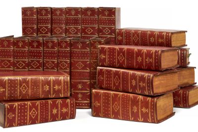 plusieurs vieux livres empilés sur une surface blanche