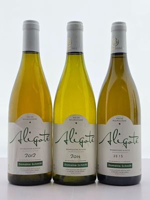 trois bouteilles de vin blanc sont alignées sur une table