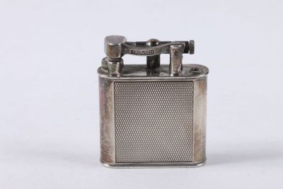 an old silver lighter with a metal cover on a white surface